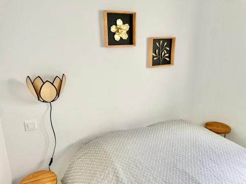 une chambre avec un lit et deux tableaux au mur dans l'établissement Plain-pied à Berck-Plage - Commerces et plage à quelques pas, à Berck-sur-Mer