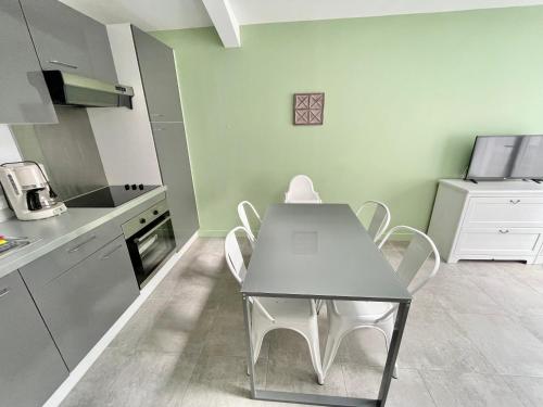 une cuisine avec une table et des chaises dans une pièce dans l'établissement Plain-pied à Berck-Plage - Commerces et plage à quelques pas, à Berck-sur-Mer