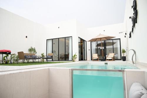 a swimming pool in front of a house at شاليه زهر Zahr Chalet in Banī Ma‘n