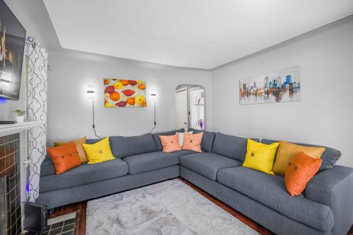 a living room with a blue couch with colorful pillows at Peaceful Detroit Home with Yard 10 Mi to Downtown! in Detroit