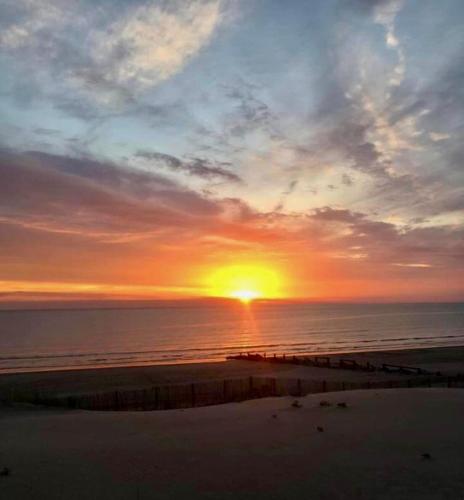 - un coucher de soleil sur une plage au coucher du soleil sur l'océan dans l'établissement Ma cour Berck/mer, à Berck-sur-Mer