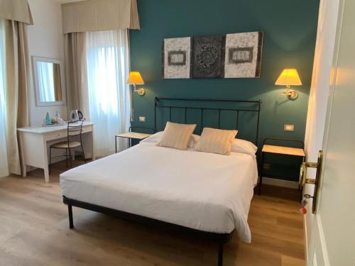 ein Schlafzimmer mit einem weißen Bett und einer grünen Wand in der Unterkunft Locanda Moscal in Affi