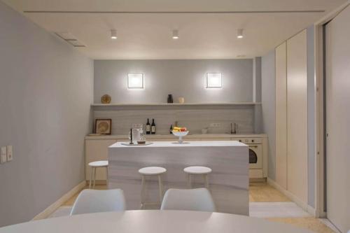 アテネにあるHolodek Apartments- Elysian Harmonyのキッチン(テーブル、椅子、カウンター付)