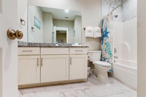 巴拿马城海滩Lagoon Luxury的带水槽、马桶和镜子的浴室