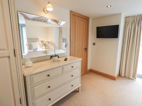 a bathroom with a dresser with a large mirror at Lime Cottage in Backbarrow