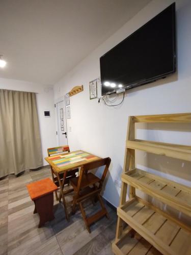 a room with a table and a tv on the wall at Las Marilubis Calamuchita in Santa Rosa de Calamuchita