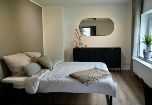 una camera da letto con un letto con uno specchio sul muro di Berga Farmhouse a Berga
