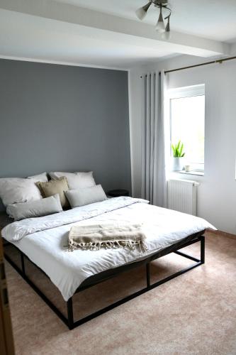 a bedroom with a bed with white sheets and a window at Berga Farmhouse in Berga