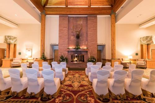 a room with white chairs and a fireplace at Holiday Inn Estes Park by IHG in Estes Park