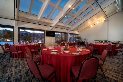 a room with red tables and chairs and windows at Holiday Inn Estes Park by IHG in Estes Park