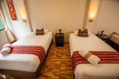 2 camas en una habitación de hotel en RUMIQOLQA Machupicchu Hotel, en Machu Picchu