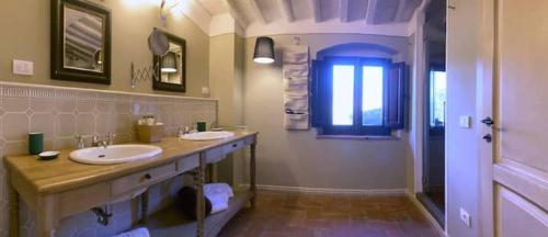 a bathroom with two sinks and a window at Borgo in Montalbano by Secret Hills in Larciano