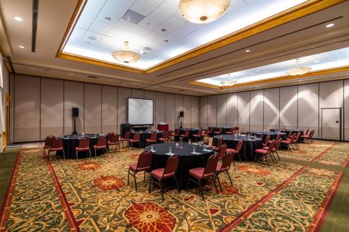 a conference room with tables and chairs and a screen at Holiday Inn Estes Park by IHG in Estes Park
