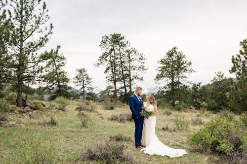 a bride and groom standing in a field at Holiday Inn Estes Park by IHG in Estes Park