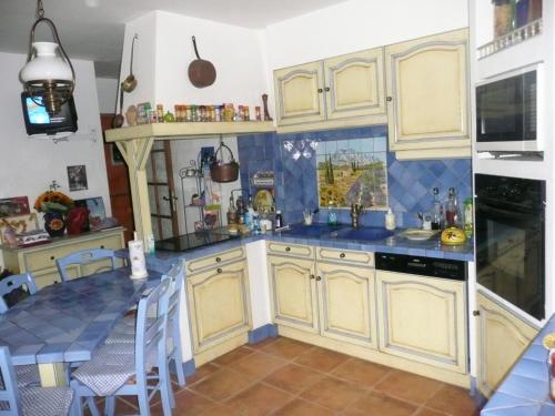 eine Küche mit gelben Schränken und blauem Fliesenboden in der Unterkunft VILLA TITOU1 in Cabriès