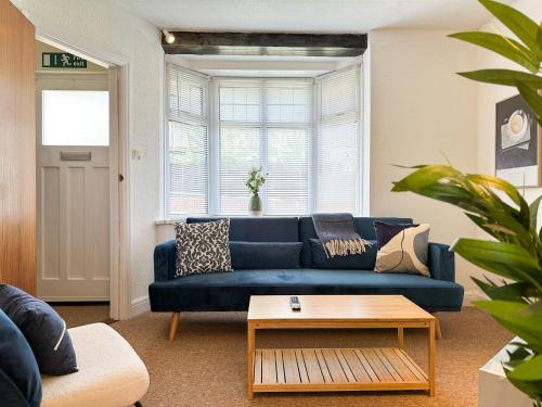 a living room with a blue couch and a table at Luxury 2-bedroom Townhouse in Central Canterbury with Hot Tub, Garden & Private Parking! in Canterbury