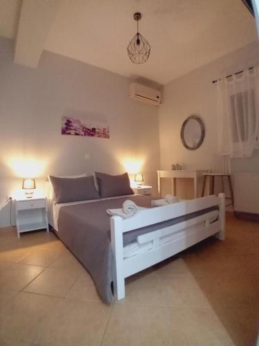 een slaapkamer met een groot wit bed en 2 lampen bij Marianna's room in Virós