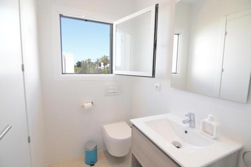 a bathroom with a toilet and a sink and a window at Apartamentos Casa Franziska in Talamanca