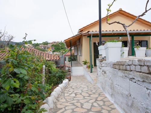 a house with a stone wall next to a sidewalk at Basil & Sunrise in Lazaráta