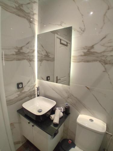 een badkamer met een wastafel, een toilet en een spiegel bij Marianna's room in Virós