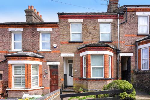 a brick house with a fence in front of it at Modern Freshly Refurbed Home Luton in Luton