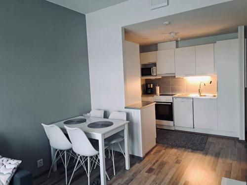 cocina con mesa y sillas blancas en una habitación en Top Floor City Apartment, en Rovaniemi