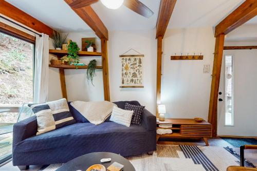 a living room with a blue couch and a window at 30A Creekside in Banner Elk