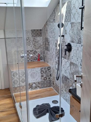 a shower with a glass door in a bathroom at Hirsch Glück in Ofterschwang