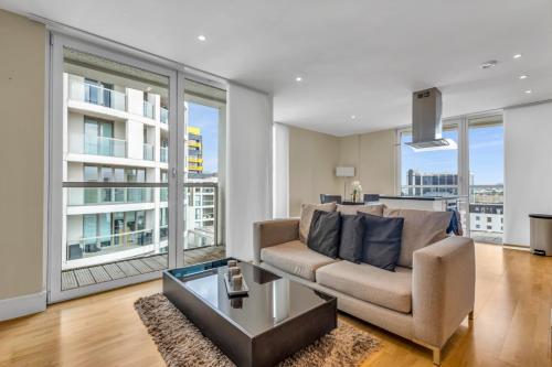 a living room with a couch and a table at MySquare Lanterns Way Apartments at Canary Wharf in London