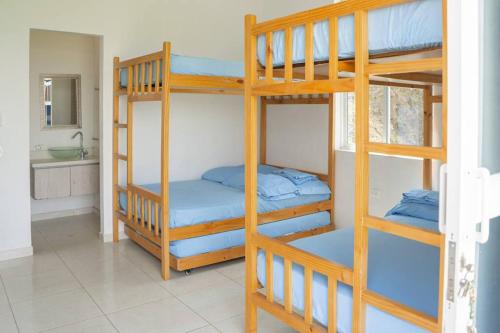 two bunk beds in a room with a bathroom at Finca Rosa Linda Stunning Views Jacuzzi Pool in Sopetrán