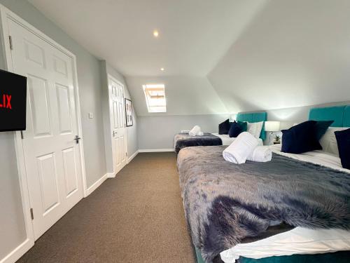 a bedroom with two beds and a tv in it at Luxury Boutique Apartments Block Free Street Parking in Hounslow
