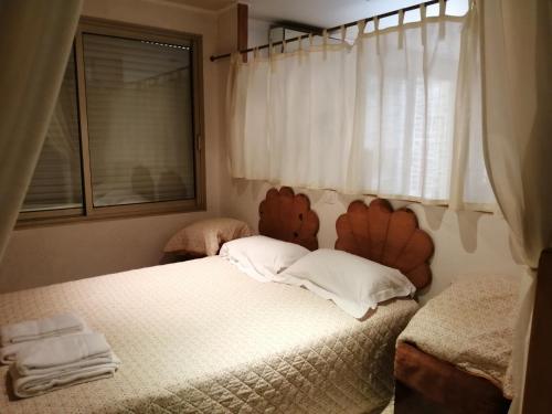 - une chambre avec un lit avec deux oreillers et une fenêtre dans l'établissement Cannes Croisette 3 Bedrooms, à Cannes