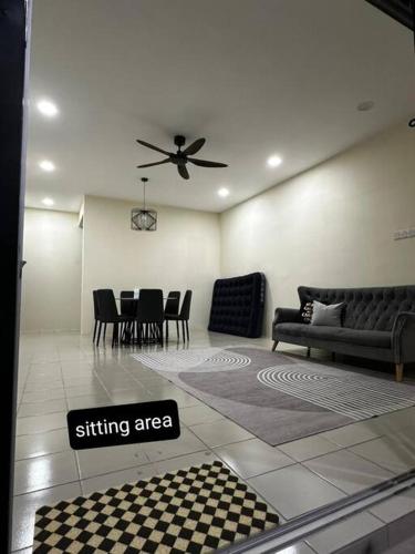 uma sala de estar com uma ventoinha de tecto e uma mesa e cadeiras em home stay murah kuantan em Kuantan