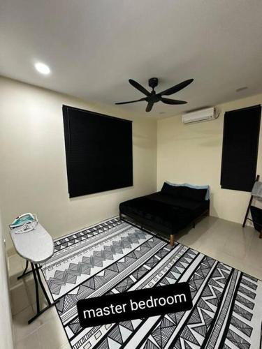 uma sala de estar com uma cama preta e uma cadeira em home stay murah kuantan em Kuantan