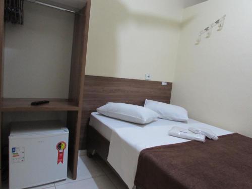 a hotel room with two beds and a refrigerator at Hotel Biz a 8 minutos do Brás, a 15 minutos da 25 de março e a 8 minutos do Bom retiro in Sao Paulo