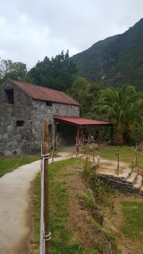 a stone building with a red roof next to a road at Nature Retreat - Laurel Forest in Seixal