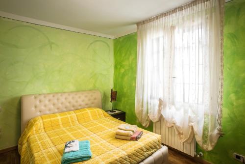 a green bedroom with a bed and a window at B&B La Petite Maison in Puegnago