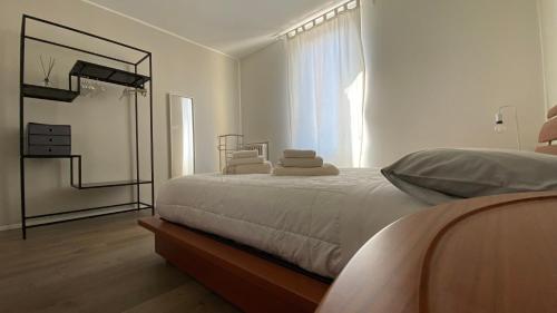 Habitación blanca con cama y espejo en Suite649 Nuova 5 en Modena