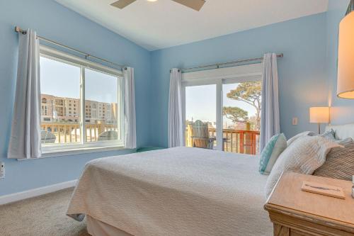 a blue bedroom with a bed and two windows at Ocean View Dauphin Island Condo with Boat Slips in Dauphin Island