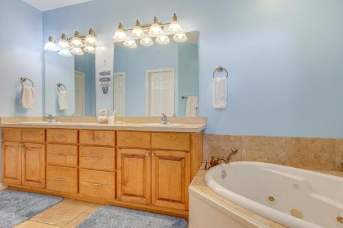 a bathroom with two sinks and a tub and a mirror at Ocean View Dauphin Island Condo with Boat Slips in Dauphin Island