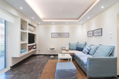 ein Wohnzimmer mit Sofa und Fernseher in der Unterkunft Vouliagmeni Sea and Sun Apartment in Athen