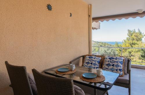 ein Tisch und Stühle mit Blick auf einen Balkon in der Unterkunft Vouliagmeni Sea and Sun Apartment in Athen