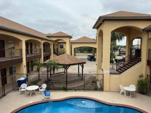 a view of a pool at a resort with chairs and a table at Texas Inn and Suites RGV in Edinburg