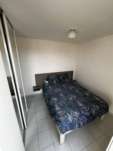 une petite chambre avec un lit dans le coin dans l'établissement Appartement 2CH, clim, piscine, garage, mer, au Grau-du-Roi