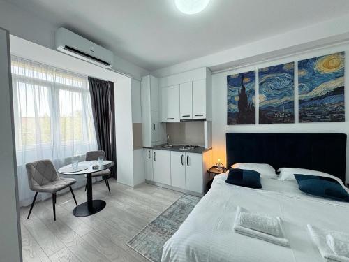 Un dormitorio con una cama y una mesa y una cocina. en North Studio, en Onești