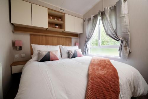 a bedroom with a large white bed with a window at Mendip Close in Burnham on Sea