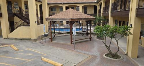 a gazebo in front of a building with a pool at Texas Inn and Suites RGV in Edinburg