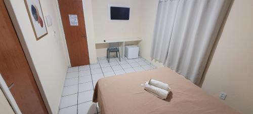 a small room with a bed with two pillows on it at Pousada Manaíra in João Pessoa