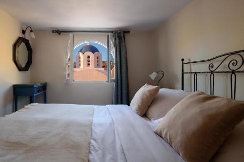 a bedroom with a large bed with a window at Ikio Concept Santorini in Pyrgos
