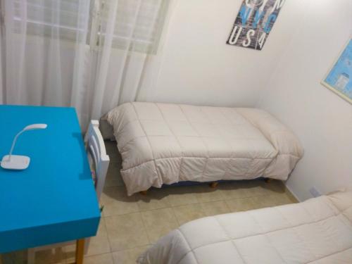 una piccola stanza con due letti e un tavolo blu di Alto Ramon a Neuquén